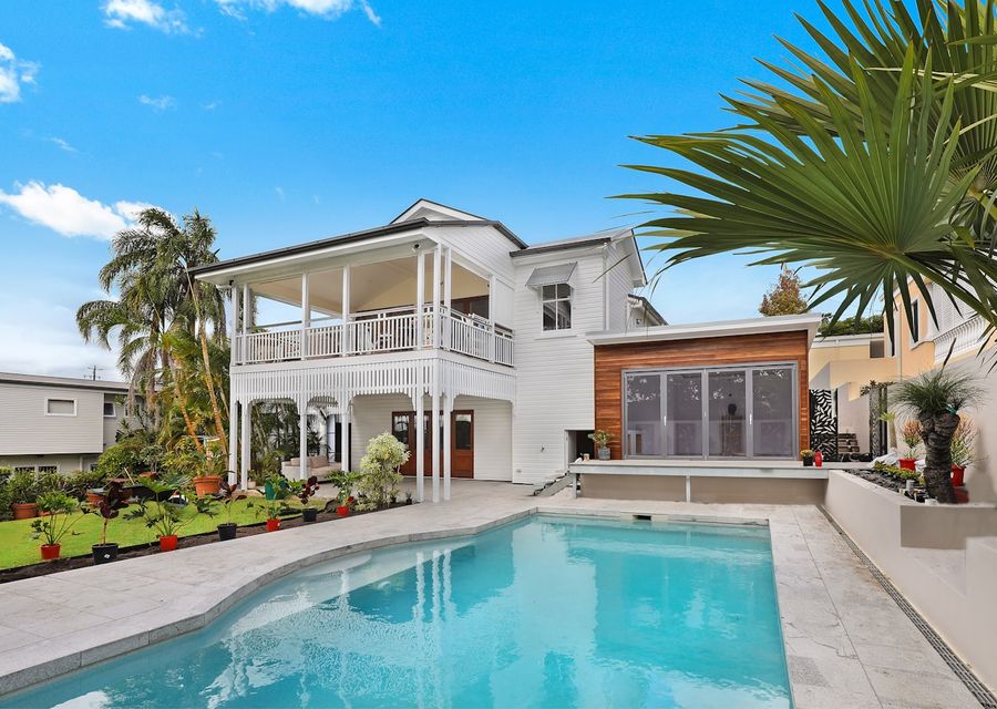 A paved pool surround and landscaped garden at a residential property